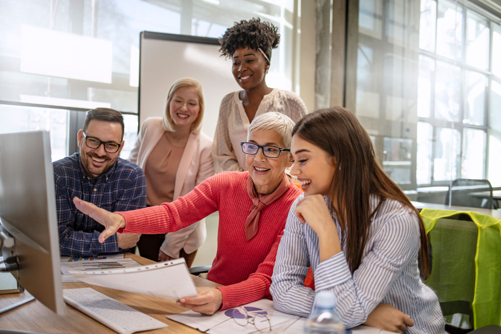 Female school buisness manager discussing work on a computer screen with her team